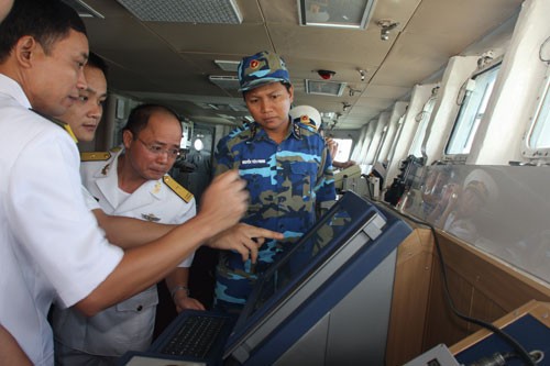 Hoa tiêu Trung Quốc (thứ hai từ trái) đang cung cấp thông tin về cảng Trạm Giang cho thuyền trưởng Nguyễn Đình Giảng và tổ lái tàu HQ-011